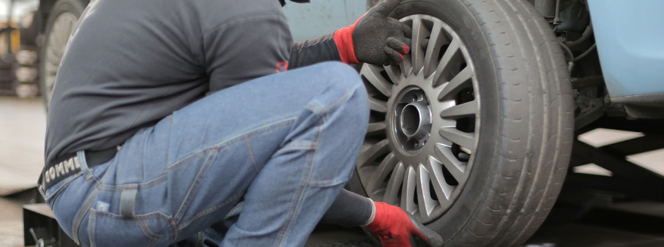 a technician in the process of rotating tires